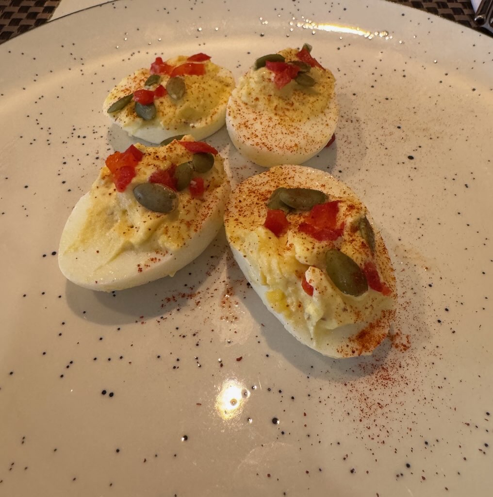 Deviled eggs with tajin, pepitas and roasted red pepper on ramen